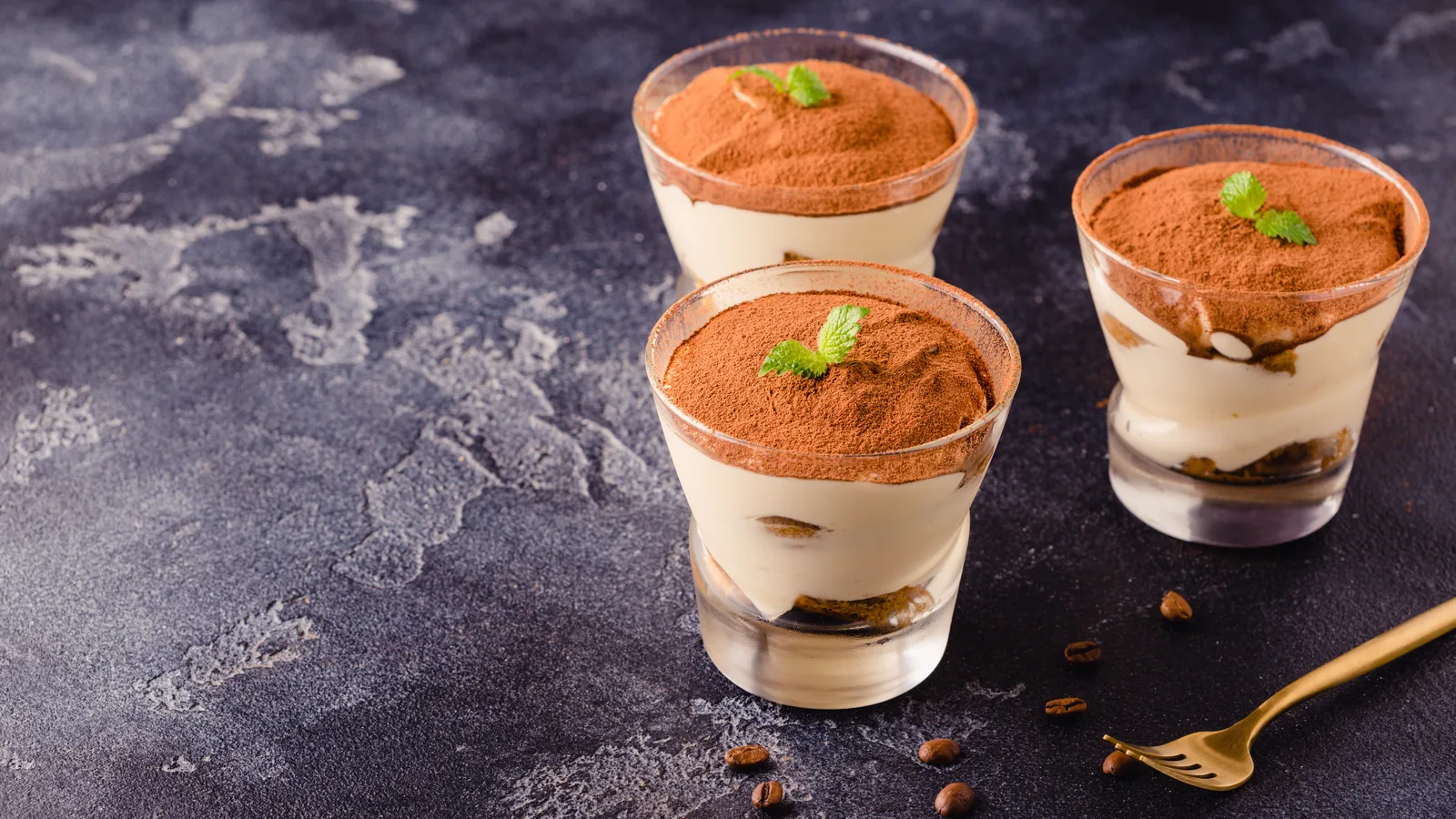 A tiramisu dessert with cocoa dusting on a counter