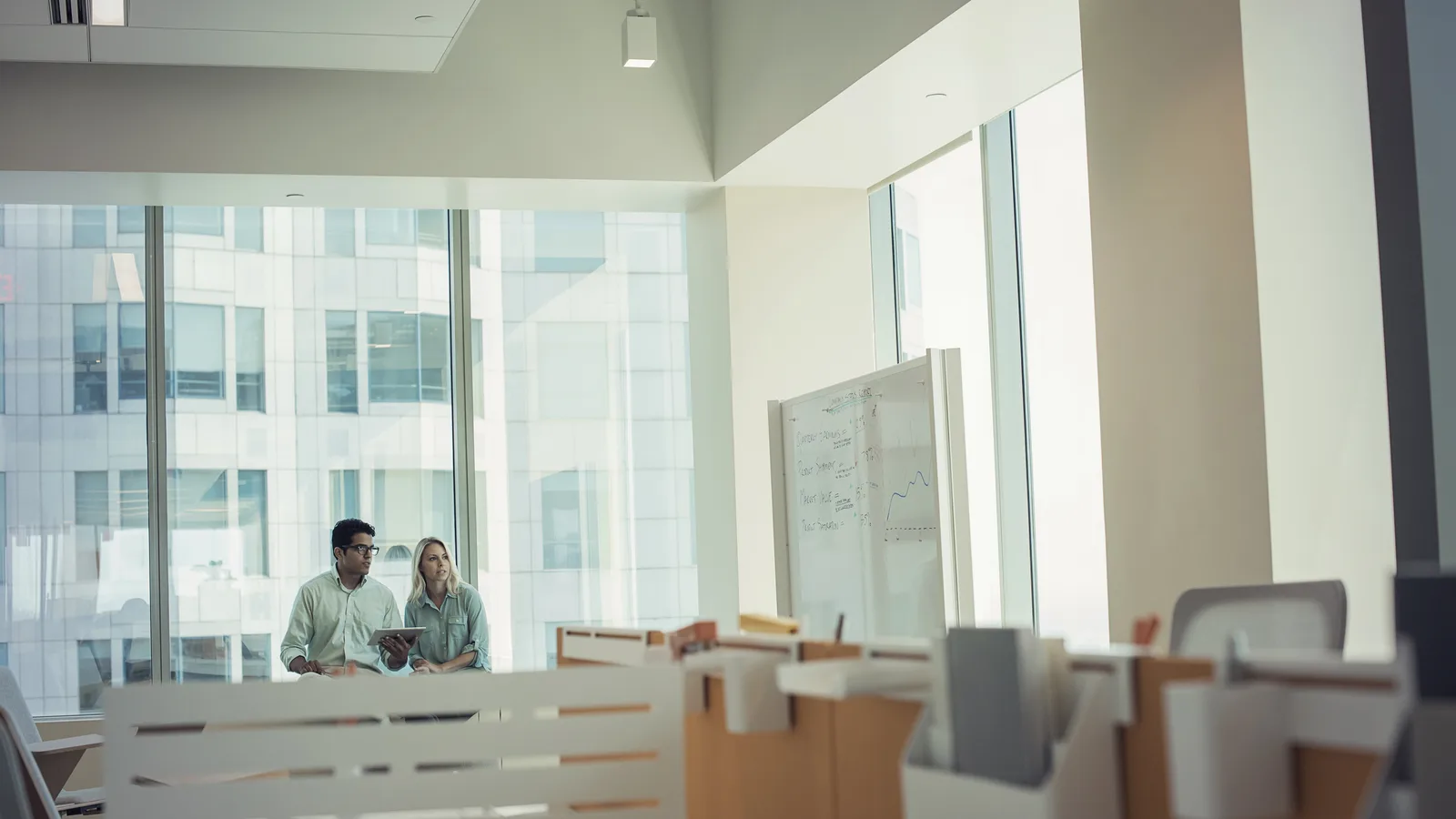 Two colleagues talking in a bright modern office